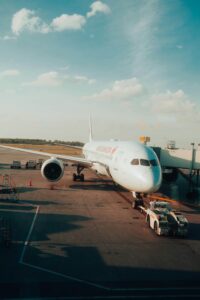 A large airplane is parked at Montreal airport tarmac under a bright blue sky.
